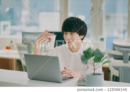 Young man doing desk work 128366148