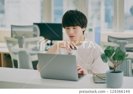 Young man doing desk work Young man doing desk work 128366149
