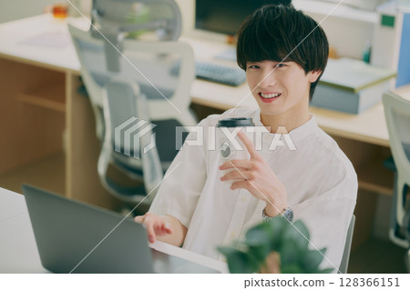 Young man doing desk work Young man doing desk work 128366151