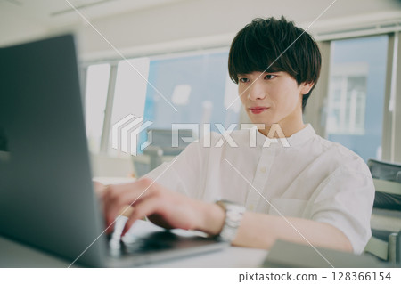 Young man doing desk work Young man doing desk work 128366154