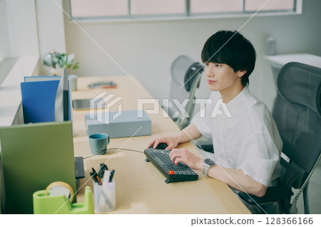 Young man doing desk work 128366166