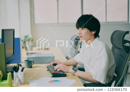 Young man doing desk work Young man doing desk work 128366170