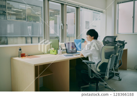Young man doing desk work 128366188