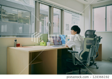 Young man doing desk work 128366192