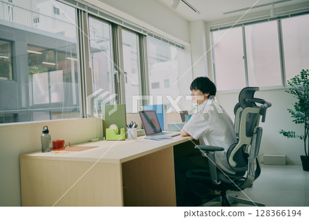 Young man doing desk work Young man doing desk work 128366194