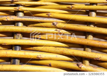 An Intricate Woven Pattern Composed of Yellow Rattan Strands Exhibiting Great Detail and Charm 128366355