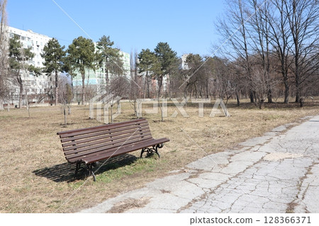 A Serene Park Bench Found in a Tranquil Urban Landscape, Ideal for Relaxation and Repose A Serene Park Bench Found in a Tranquil Urban Landscape, Ideal for Relaxation and Repose 128366371