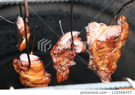 Enjoy flavorful smoked meat on skewers, creatively prepared in a cooker for a tasty experience 128366457