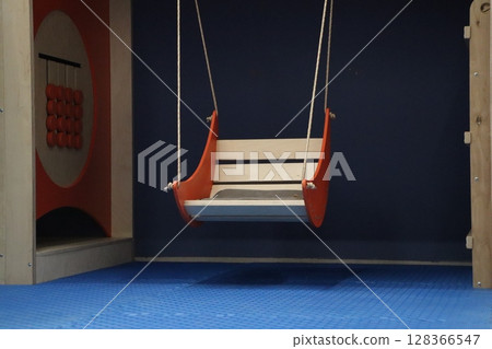 A modern childrens swing for a cozy playroom, blending fun and safety in design 128366547