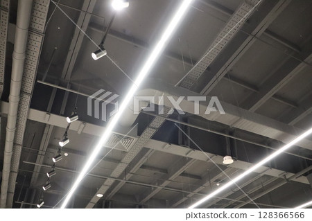 A contemporary industrial ceiling with sleek lighting fixtures offers a modern feel 128366566