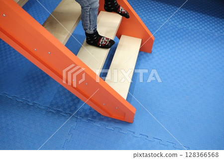 Childrens Play Area Featuring a Brightly Colored Slide and Inviting Blue Flooring for Fun Childrens Play Area Featuring a Brightly Colored Slide and Inviting Blue Flooring for Fun 128366568