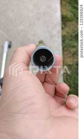 A Detailed CloseUp of a Pipe Opening Captured with the Help of a Hand for Analysis A Detailed CloseUp of a Pipe Opening Captured with the Help of a Hand for Analysis 128366924