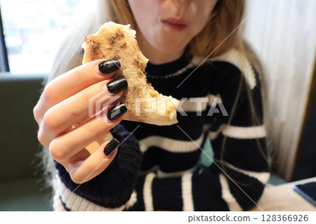 Casual Dining Relishing a Delicious Bite of Freshly Baked Bread in a Cozy Atmosphere Casual Dining Relishing a Delicious Bite of Freshly Baked Bread in a Cozy Atmosphere 128366926