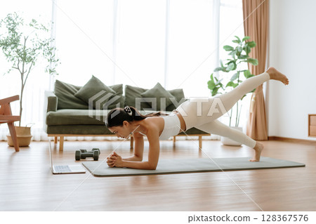 Young Asian woman in sportswear doing plank on training mat Young Asian woman in sportswear doing plank on training mat 128367576