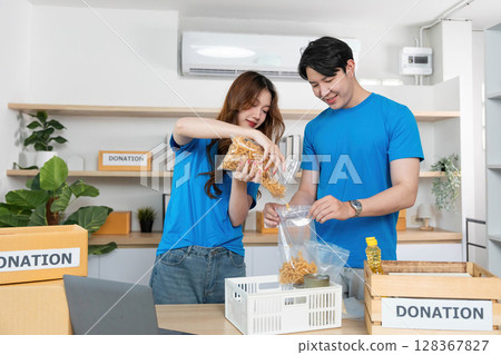 Donation Process. Volunteers packing food items for charity in a community center. Donation Process. Volunteers packing food items for charity in a community center. 128367827