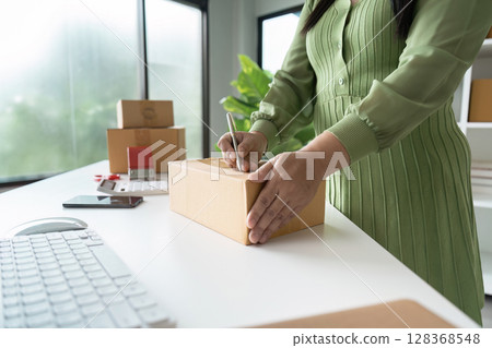 Senior Entrepreneur Preparing Packages for Shipping in a Modern Home Office Setting Senior Entrepreneur Preparing Packages for Shipping in a Modern Home Office Setting 128368548