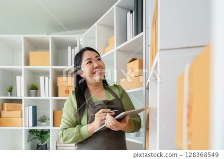 Senior Entrepreneur Organizing Inventory in Modern Office Space for New Business Startup 128368549