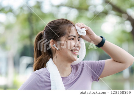 Smiling Woman Enjoying Outdoor Jogging Session, Embracing Wellness and Fitness with a Refreshing Workout in Nature 128368599