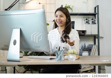 Professional Call Center Agent Providing Customer Support with Headset in Modern Office Environment Professional Call Center Agent Providing Customer Support with Headset in Modern Office Environment 128368805