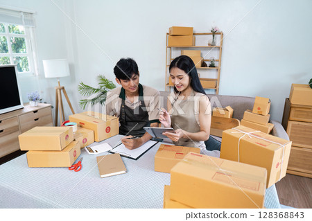 Business Startup owner Working From Home Packaging Products and Using tablet 128368843