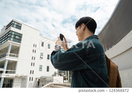 Young Traveler Capturing Modern Architecture on Mobile During Urban Exploration Young Traveler Capturing Modern Architecture on Mobile During Urban Exploration 128368872