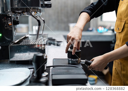 Barista Preparing Espresso with Professional Coffee Machine in Modern Cafe Barista Preparing Espresso with Professional Coffee Machine in Modern Cafe 128368882