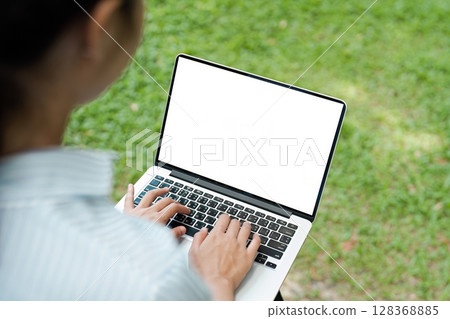 Woman Working on Laptop Outdoors in a Park with Blank Screen - Remote Work and Digital Nomad Lifestyle Concept Woman Working on Laptop Outdoors in a Park with Blank Screen - Remote Work and Digital Nomad Lifestyle Concept 128368885
