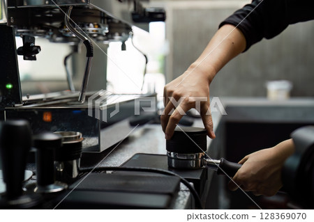Barista Preparing Espresso with Professional Coffee Machine in Modern Cafe 128369070