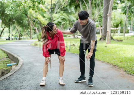 Young Couple Enjoying a Refreshing Jog in a Lush Green Park on a Sunny Day Young Couple Enjoying a Refreshing Jog in a Lush Green Park on a Sunny Day 128369115
