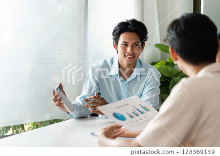 Young Couple Planning Savings and Banking with Financial Advisor in Modern Office Setting Young Couple Planning Savings and Banking with Financial Advisor in Modern Office Setting 128369139