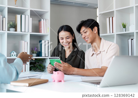 Happy Couple Planning Savings and Banking Together at Home with Financial Advisor 128369142