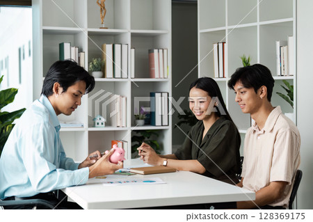 Young Couple Planning Savings and Banking with Financial Advisor in Modern Office Setting 128369175