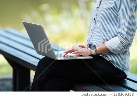 Digital Nomad Working Outdoors on Laptop, Embracing Remote Work Lifestyle in Natural Setting Digital Nomad Working Outdoors on Laptop, Embracing Remote Work Lifestyle in Natural Setting 128369338