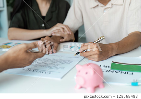 Young Couple Engaged in Financial Planning and Budgeting and signature with Documents and Adviser Financial Young Couple Engaged in Financial Planning and Budgeting and signature with Documents and Adviser Financial 128369488