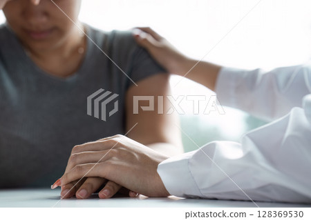 Compassionate Doctor Providing Support and Comfort to a Patient in a Healthcare Setting Compassionate Doctor Providing Support and Comfort to a Patient in a Healthcare Setting 128369530
