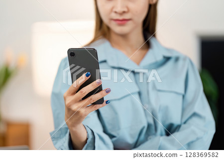 Professional Woman Working from Home Using Smartphone for Remote Business Communication 128369582