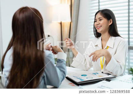 Business Strategy Planning Meeting with Financial Reports and Data Analysis Charts in Modern Office 128369588