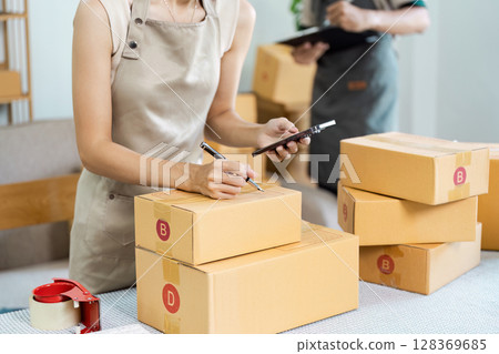 Small Business Owner Preparing Packages for Online Shipping in a Modern Home Office Environment 128369685
