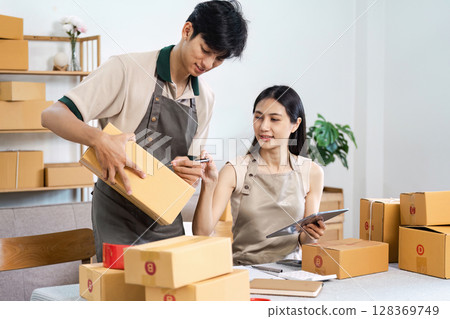 Young Entrepreneur Working Together in a Modern Small Business Packaging and Shipping Products Young Entrepreneur Working Together in a Modern Small Business Packaging and Shipping Products 128369749