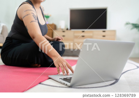 Overweight Person Engaging in Home Workout for Wellness with Laptop Guidance Overweight Person Engaging in Home Workout for Wellness with Laptop Guidance 128369789