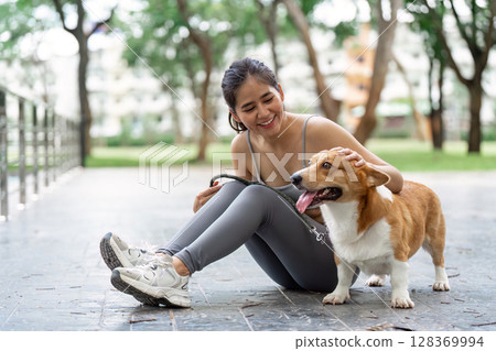 Wellness and Companionship. Woman enjoying time with her corgi dog. 128369994