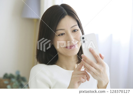 A woman watching a smartphone 128370127