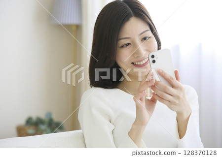 A woman watching a smartphone 128370128