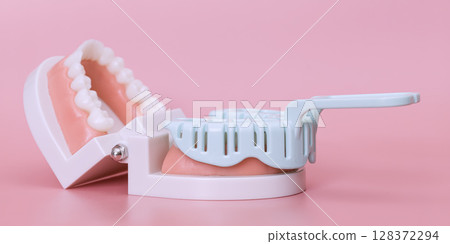 Dental impression tray and teeth model on pink 128372294