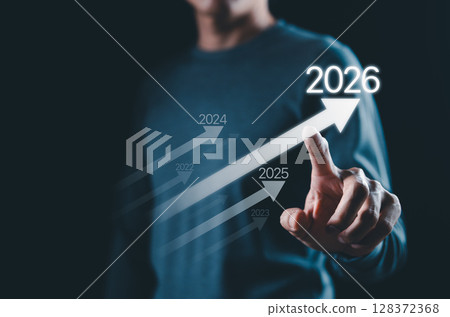 Business growth strategy towards 2026 Concept. Person points at arrow 2026, with progress arrows from previous years, symbolizing business growth, planning future for achieving success and milestones. 128372368