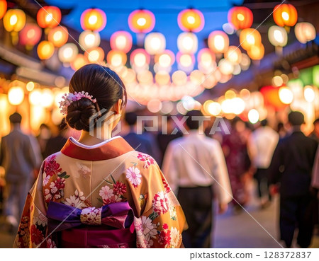 A woman in a yukata walking through the festival grounds at night 128372837