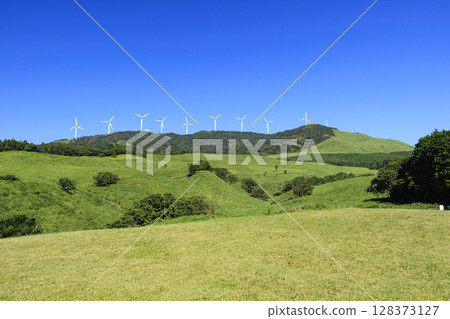 Photographing a landscape with wind turbines generating electricity against a clear blue sky Photographing a landscape with wind turbines generating electricity against a clear blue sky 128373127
