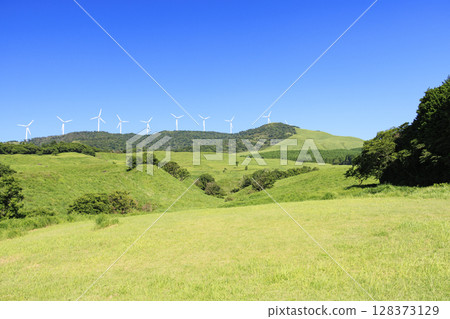 Photographing a landscape with wind turbines generating electricity against a clear blue sky 128373129