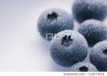 Frost-Kissed Blueberries Covered in Dewy Ice Droplets against Cool Gradient Background 128374056