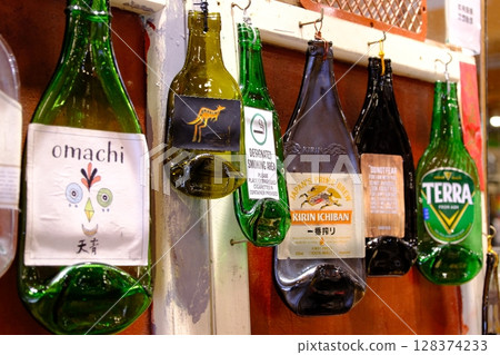 Many bottles hanging on the wall 128374233